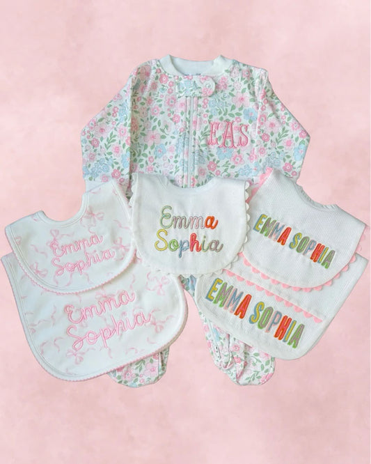 A personalized embroidered baby gift set with matching bibs