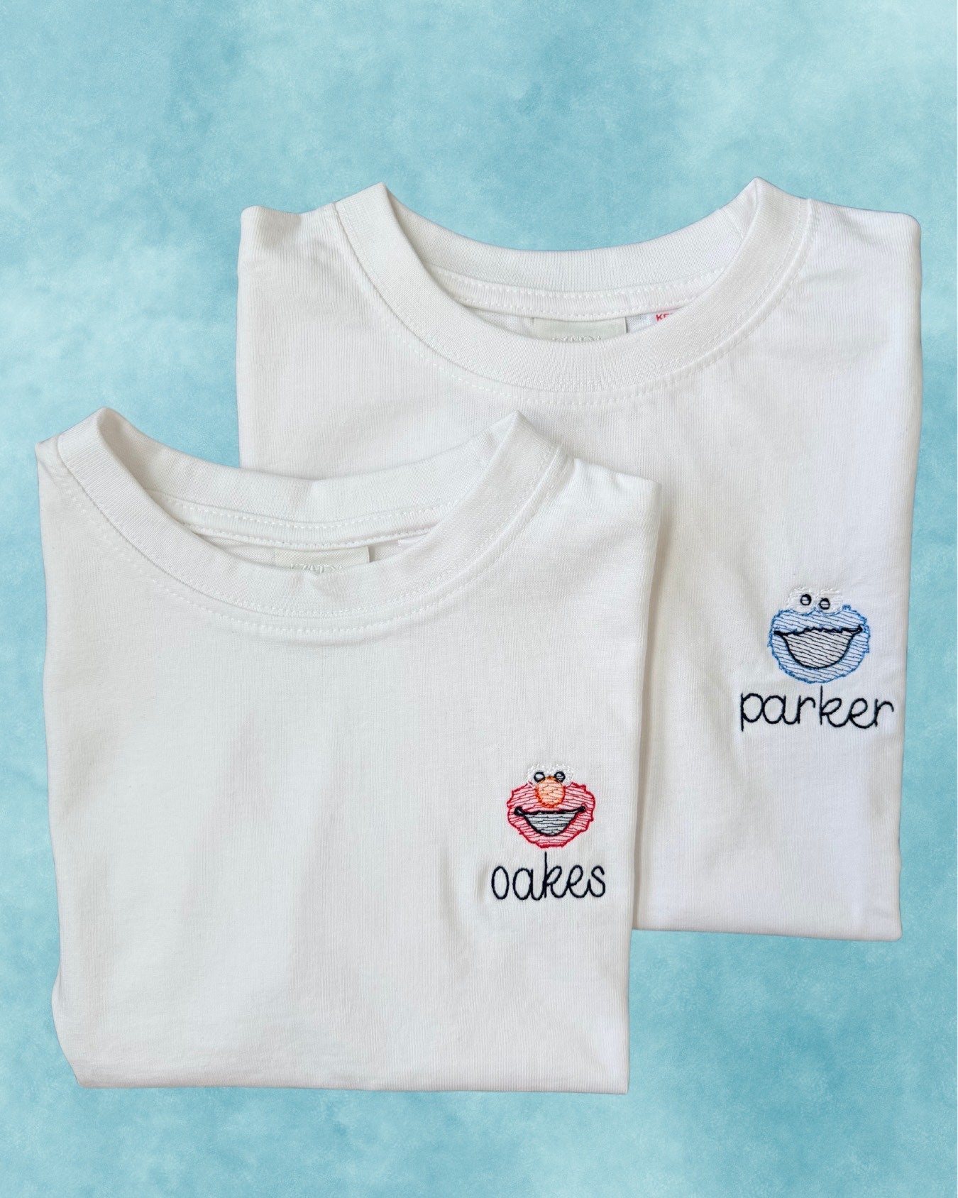 Personalized white tees — embroidered character motifs with names on the chest