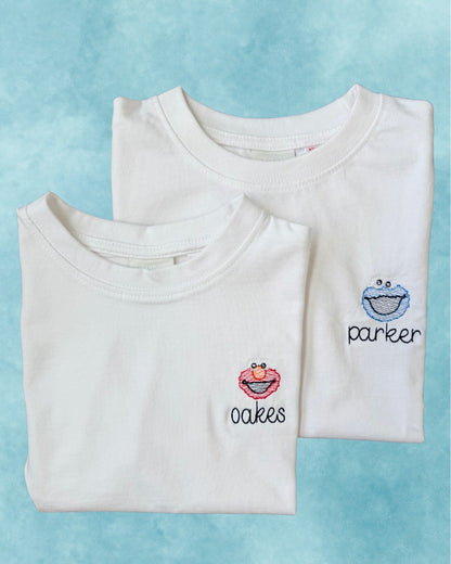 Personalized white tees — embroidered character motifs with names on the chest
